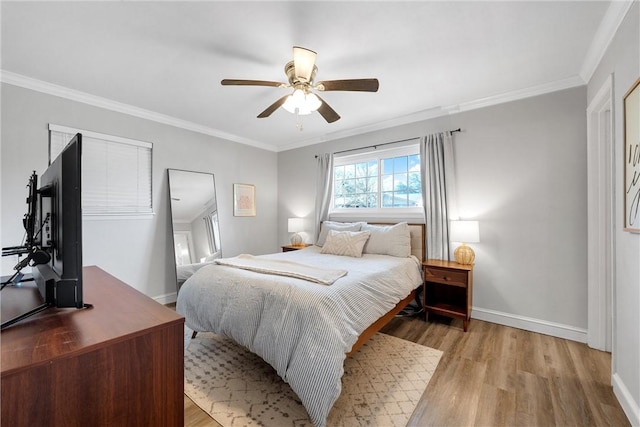 bedroom featuring baseboards, crown molding, light wood-style floors, and a ceiling fan