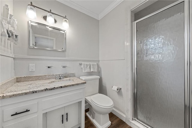 bathroom featuring vanity, toilet, a stall shower, and ornamental molding