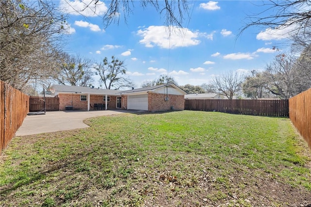 view of yard featuring a patio, concrete driveway, a fenced backyard, and a garage