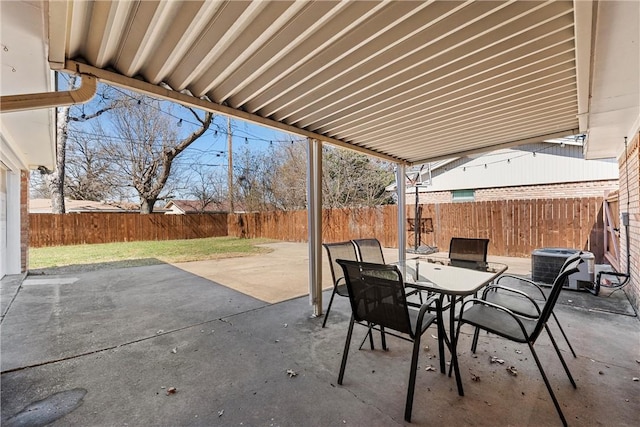 view of patio / terrace with outdoor dining area, central AC, and a fenced backyard