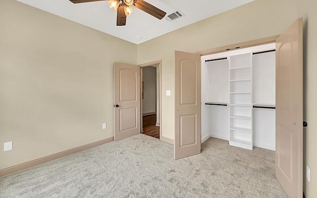 unfurnished bedroom with ceiling fan, light carpet, and a closet