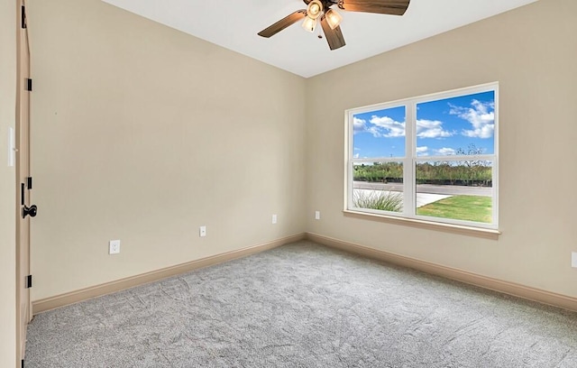 carpeted spare room featuring ceiling fan