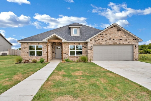 craftsman-style house featuring central AC unit, a garage, and a front lawn