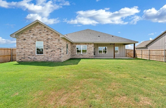 back of property with a patio, ceiling fan, and a lawn