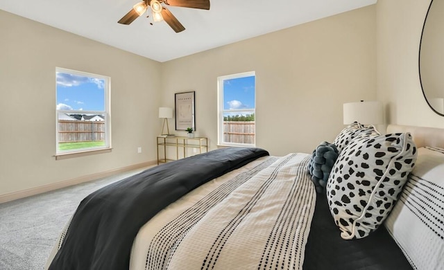 bedroom featuring carpet flooring, multiple windows, and ceiling fan