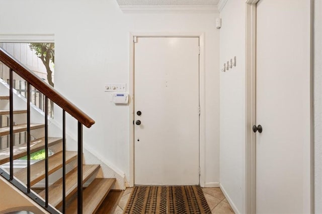 foyer with tile patterned flooring and ornamental molding