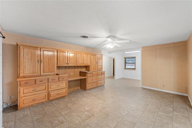 kitchen with ceiling fan, light brown cabinets, and a textured ceiling