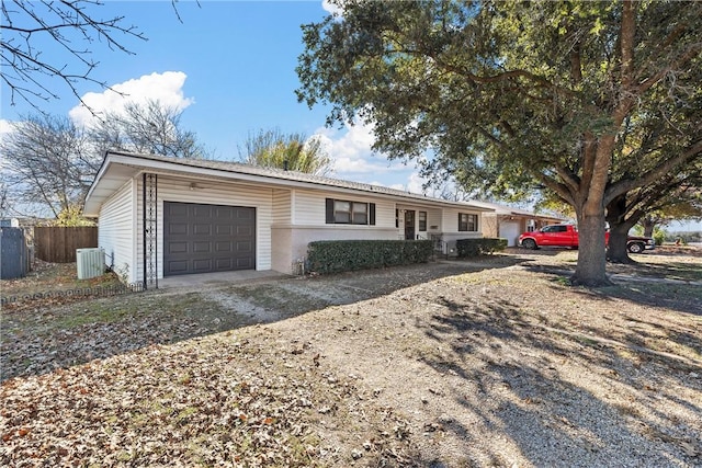 single story home featuring central AC unit and a garage