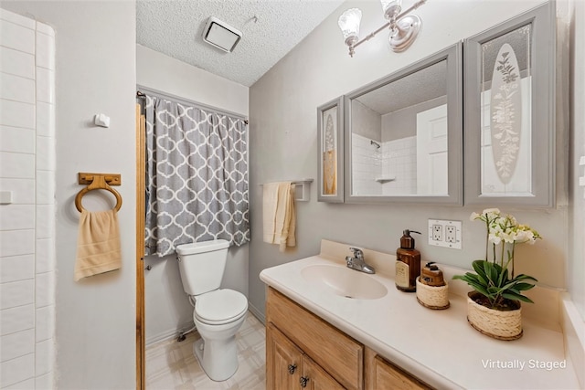 bathroom with vanity, a textured ceiling, and toilet