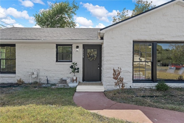 doorway to property featuring a lawn