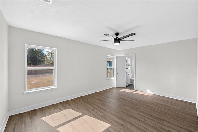 empty room featuring a textured ceiling, dark hardwood / wood-style floors, and ceiling fan