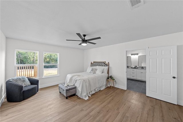 bedroom with light wood-type flooring, ensuite bath, and ceiling fan