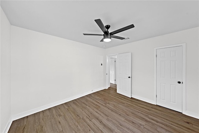 unfurnished bedroom with ceiling fan and dark hardwood / wood-style flooring