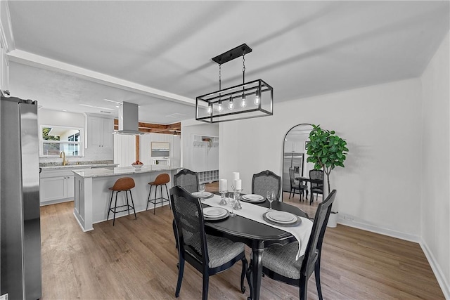 dining room with light hardwood / wood-style floors and sink