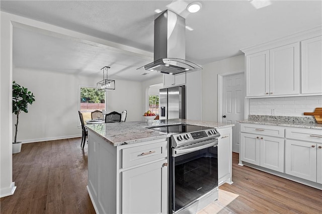 kitchen with island exhaust hood, appliances with stainless steel finishes, white cabinets, and a kitchen island with sink