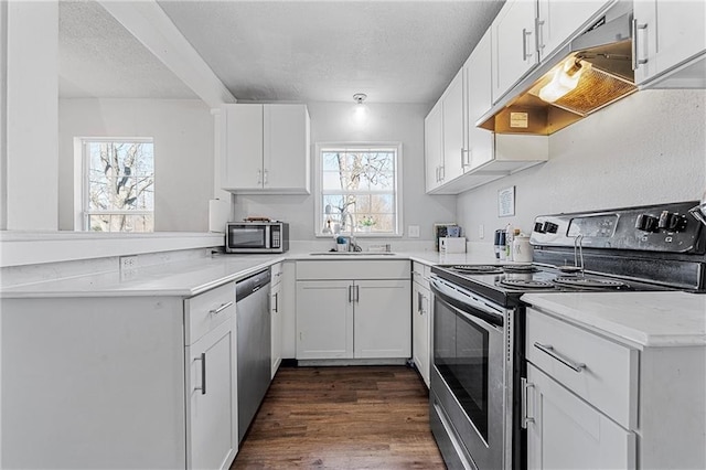 kitchen with a wealth of natural light, white cabinetry, sink, and appliances with stainless steel finishes