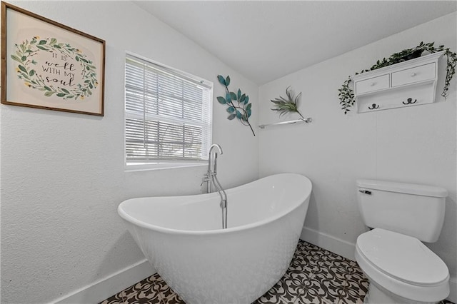 bathroom featuring a bath, tile patterned floors, toilet, and lofted ceiling