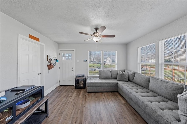 living room with a textured ceiling, light hardwood / wood-style floors, and ceiling fan