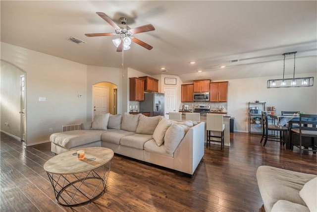 living room featuring ceiling fan and dark wood-type flooring