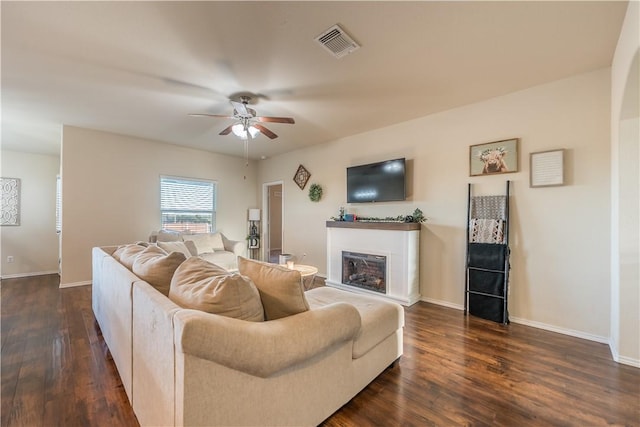 living room with ceiling fan and dark wood-type flooring