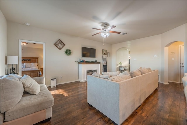 living room featuring ceiling fan and dark hardwood / wood-style flooring