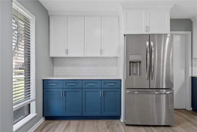 kitchen featuring white cabinetry, light countertops, blue cabinets, and stainless steel refrigerator with ice dispenser