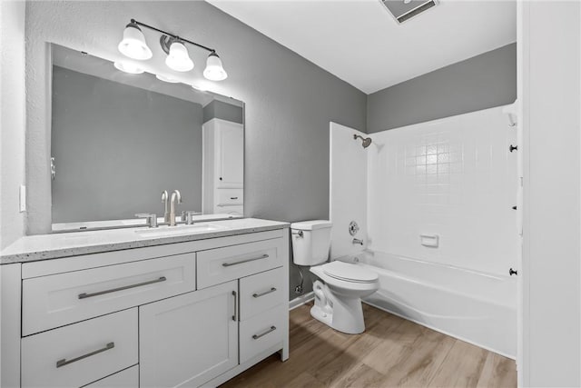 full bath featuring visible vents, toilet, wood finished floors, vanity, and  shower combination