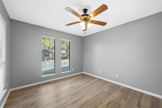 unfurnished room featuring a ceiling fan, baseboards, and light wood finished floors