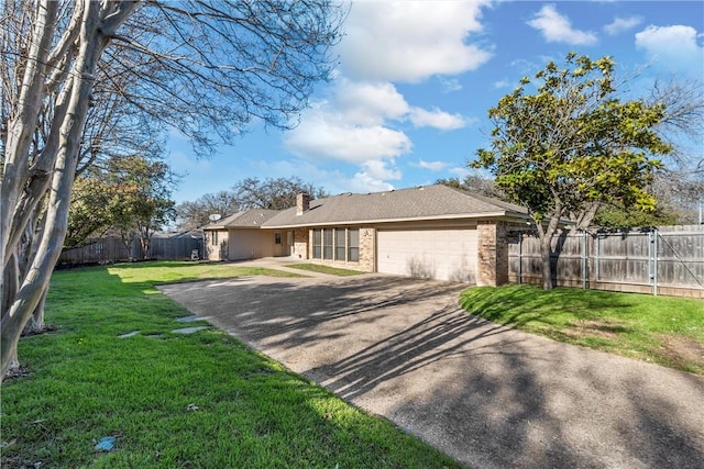 ranch-style house featuring fence, a front yard, a chimney, a garage, and driveway