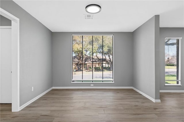 unfurnished dining area featuring visible vents, baseboards, and wood finished floors