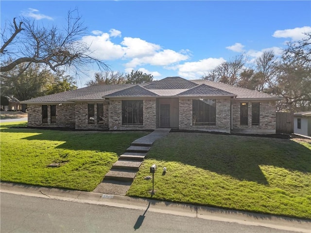 view of front of home featuring a shingled roof and a front yard