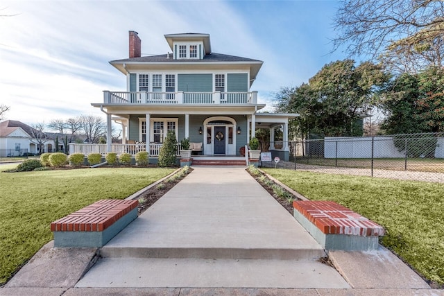 view of front of home with a front lawn, a balcony, and a porch