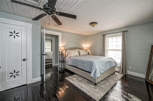 bedroom featuring multiple windows, dark wood-type flooring, and wooden ceiling