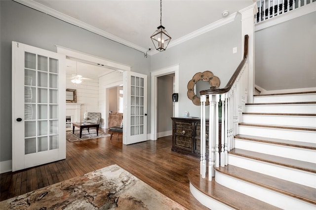 foyer entrance with dark hardwood / wood-style floors, ornamental molding, french doors, and ceiling fan