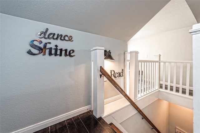 stairway featuring hardwood / wood-style flooring and a textured ceiling