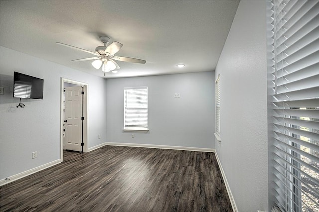 spare room featuring ceiling fan and dark wood-type flooring