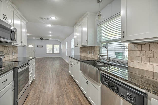 kitchen featuring white cabinets, decorative light fixtures, appliances with stainless steel finishes, and tasteful backsplash