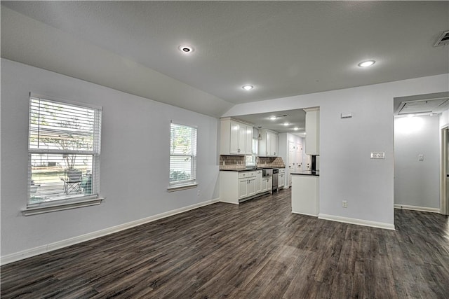 unfurnished living room featuring lofted ceiling and dark wood-type flooring