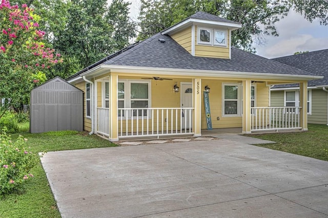 bungalow with a front yard, a porch, and a storage shed