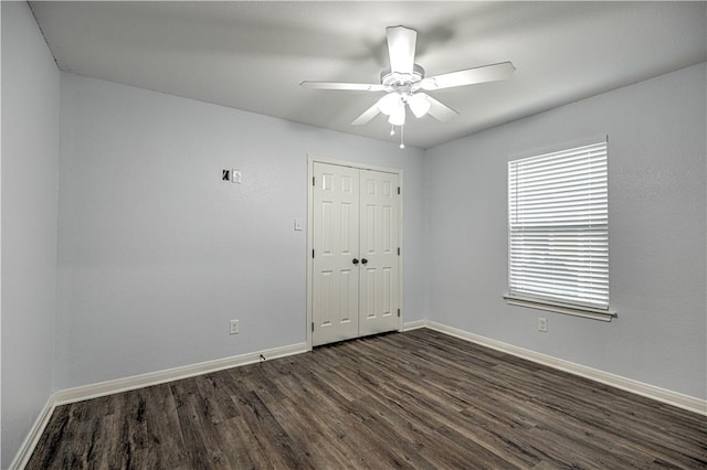 empty room with ceiling fan and dark wood-type flooring