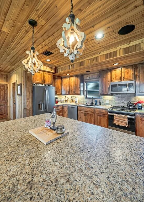 kitchen with decorative light fixtures, sink, a chandelier, stainless steel appliances, and wooden ceiling