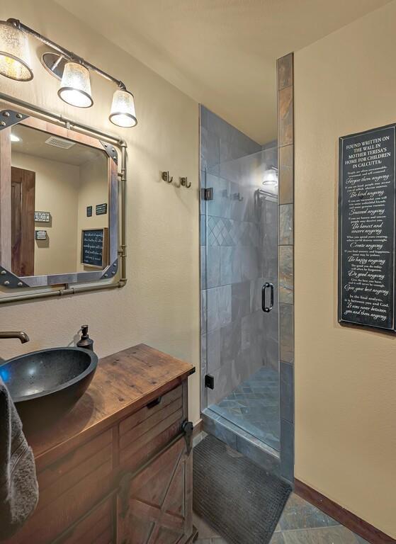 bathroom featuring vanity and a shower with door