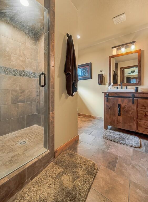 bathroom with vanity and a shower with door