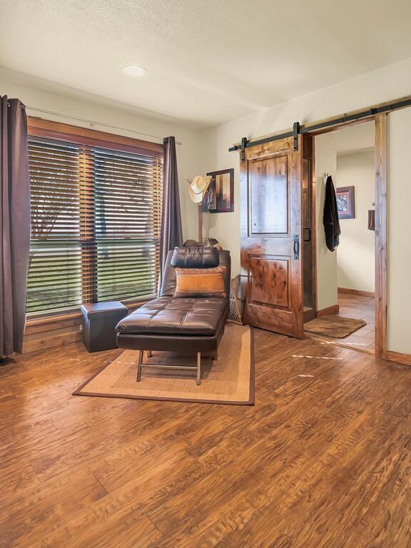 sitting room featuring a barn door and hardwood / wood-style floors