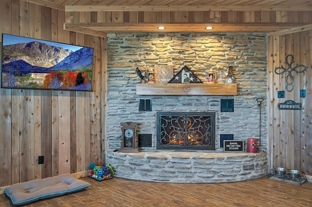 living room with hardwood / wood-style flooring, a fireplace, and wooden walls