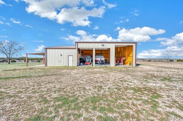 view of outdoor structure featuring a garage and a rural view