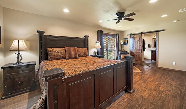 bedroom featuring dark wood-type flooring, a barn door, and ceiling fan