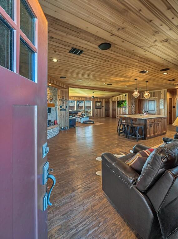 living room featuring hardwood / wood-style flooring, wooden walls, and wooden ceiling