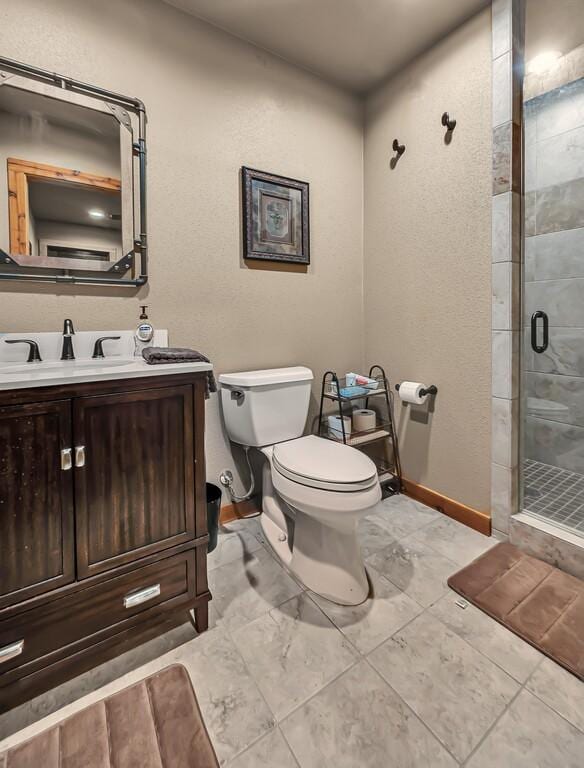 bathroom featuring vanity, toilet, and an enclosed shower