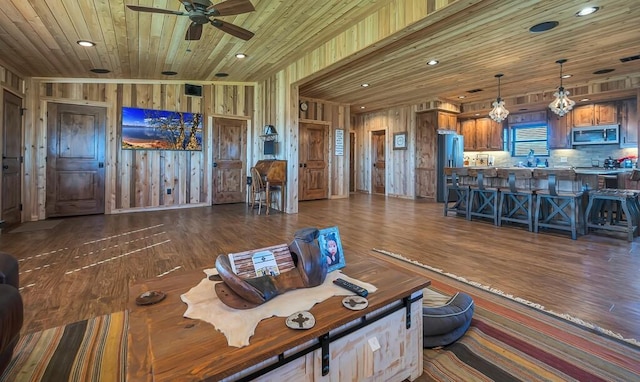 unfurnished living room featuring ceiling fan, dark hardwood / wood-style floors, sink, and wooden ceiling